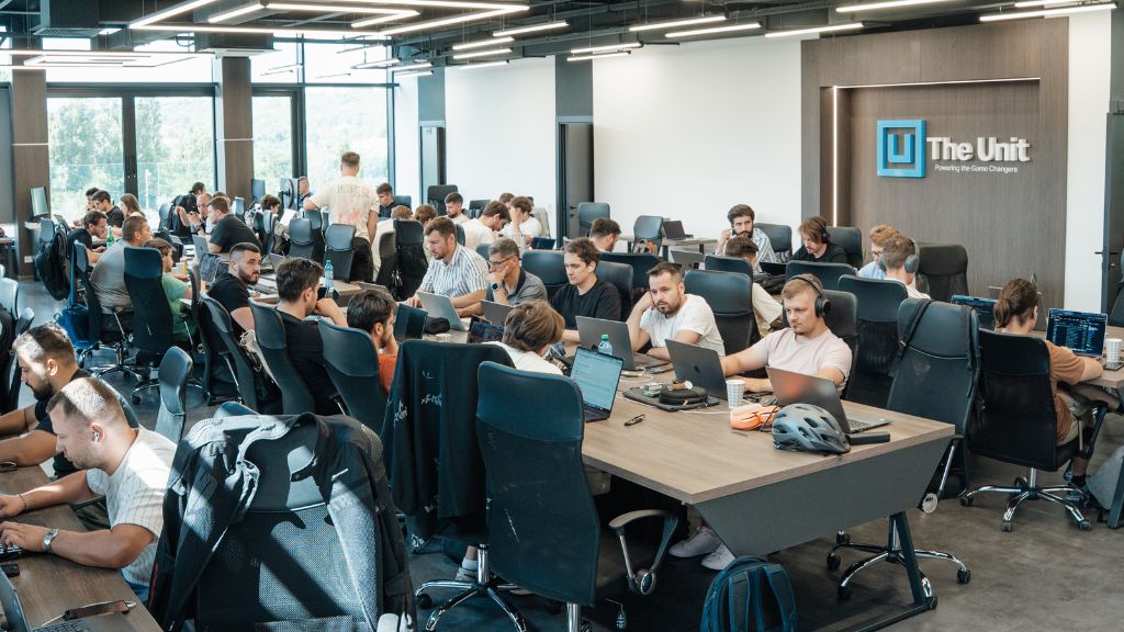 The Unit's Moldova team at work in the new open-plan Chișinău development hub, with the company logo on the wall.